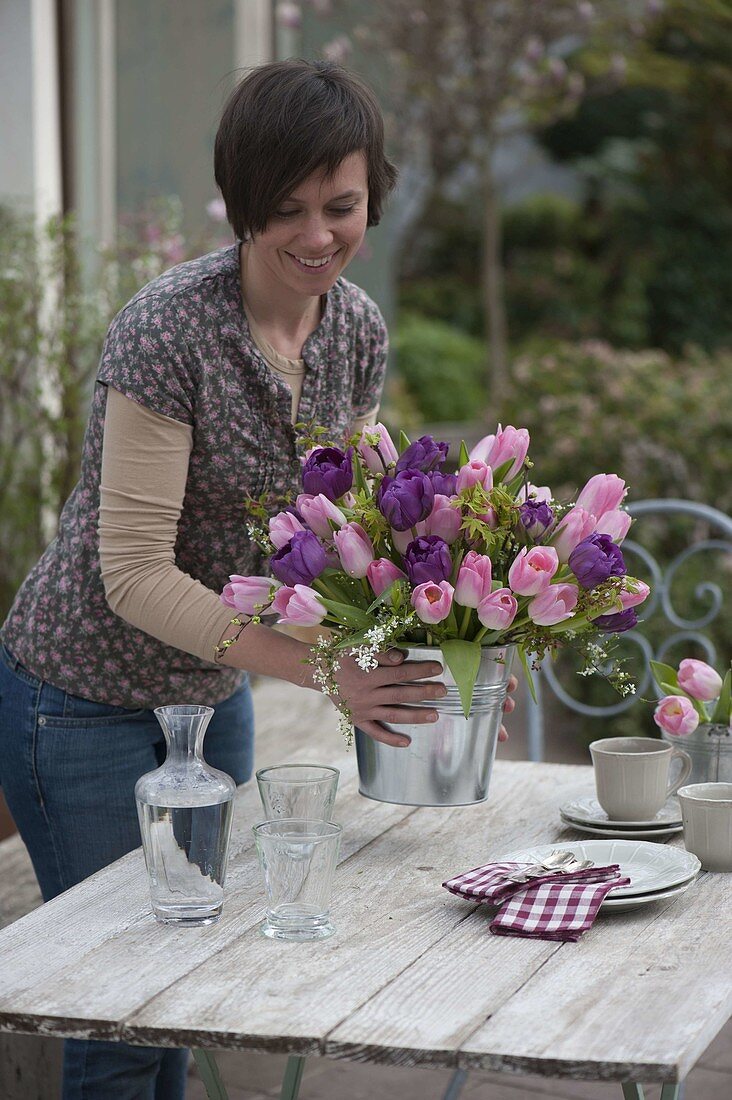 Frau mit Frühlingsstrauß aus Tulpen und Gehölz-Zweigen