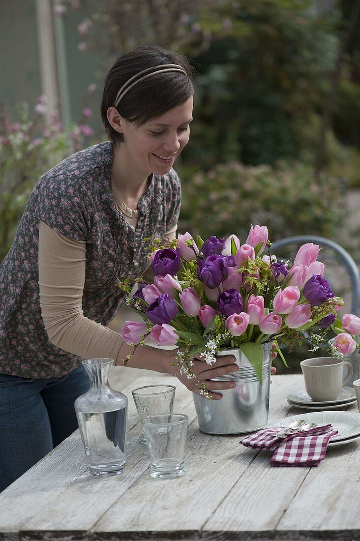 Woman with spring bouquet of tulips and woody twigs