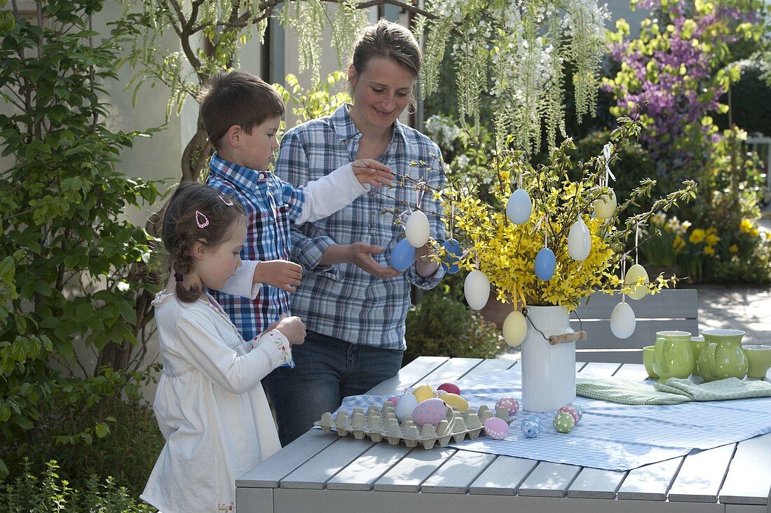 Woman with children decorating Easter bouquet