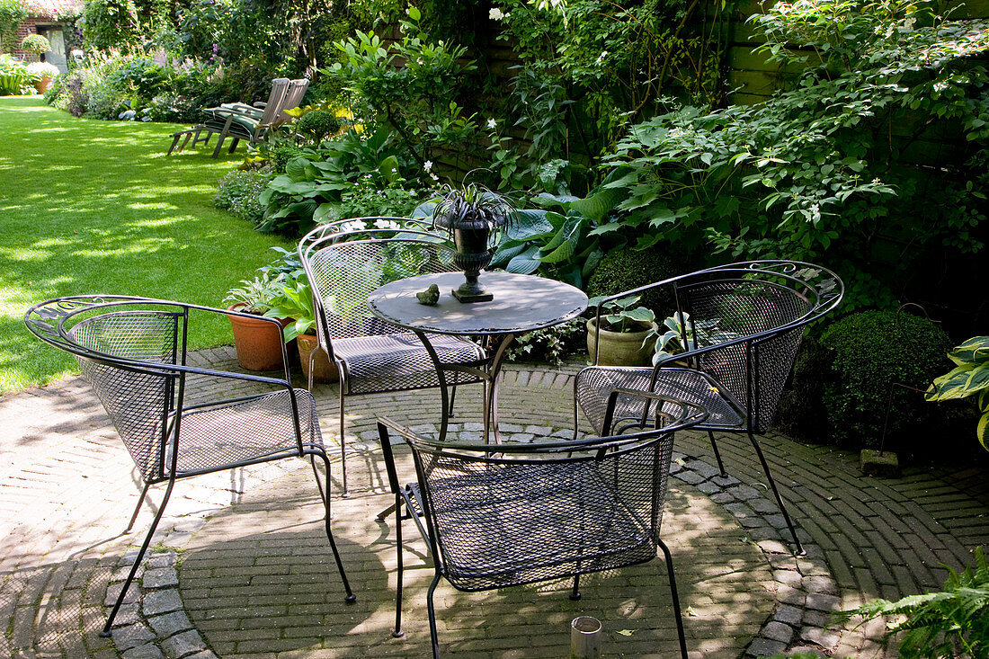 Paved round terrace with seating group in the shade