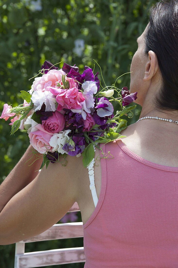 Woman with bouquet of Lathyrus odoratus (sweet pea)