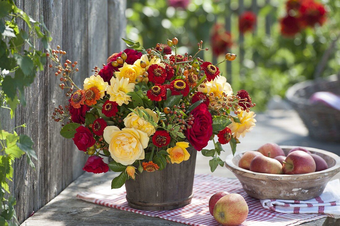 Red-yellow late summer bouquet in wooden pot