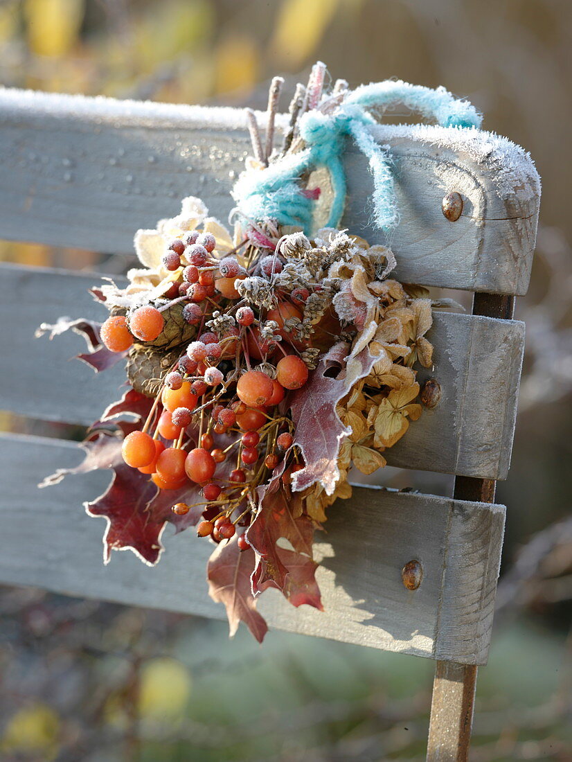 Frozen autumn bouquet with Malus (ornamental apples), pink (rose hips)