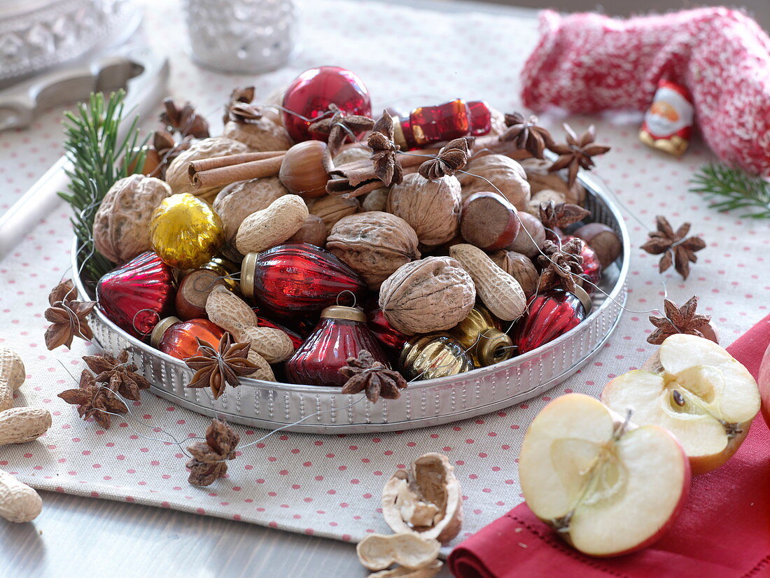 Silver tray filled with walnuts (Juglans), peanuts