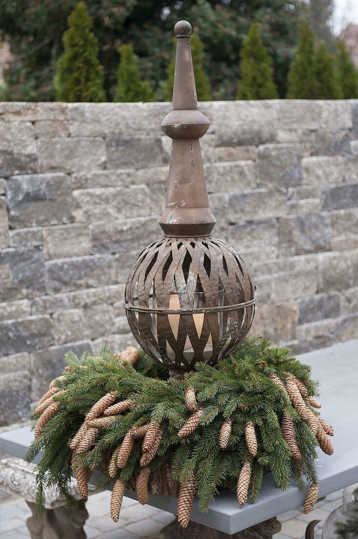 Arts and crafts lantern of metal with wreath of picea (spruce) with cones