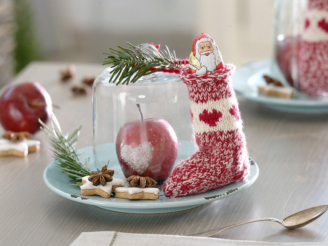 Nikolaus-Teller mit gefülltem Söckchen, Schoko-Nikolaus, Apfel mit Herz aus Zucker unter Glasglocke