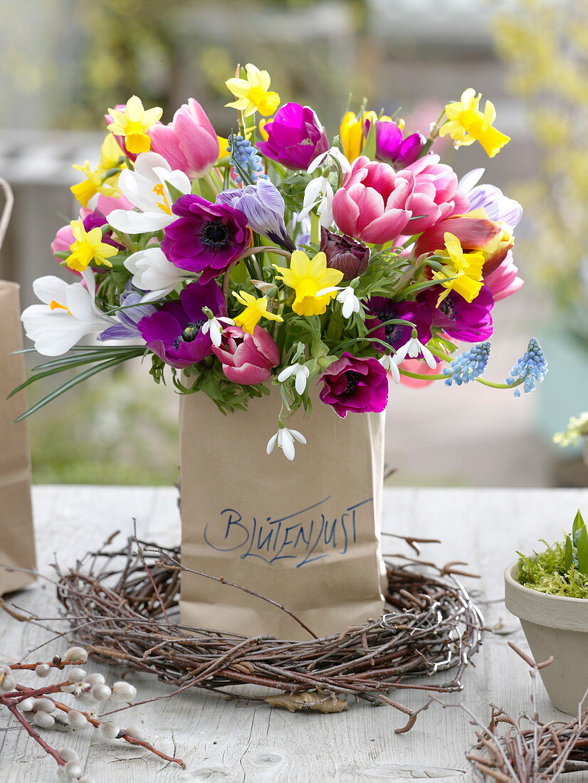 Colorful spring bouquet in paper bag with inscription