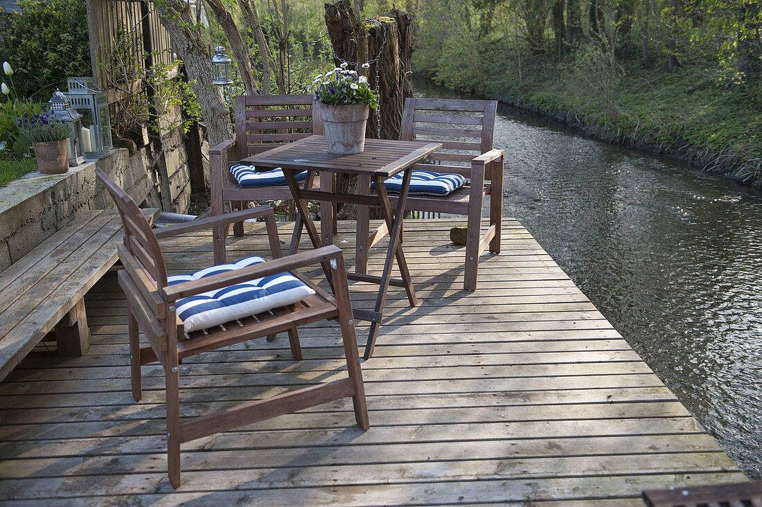 Wooden terrace with seating area by the watercourse