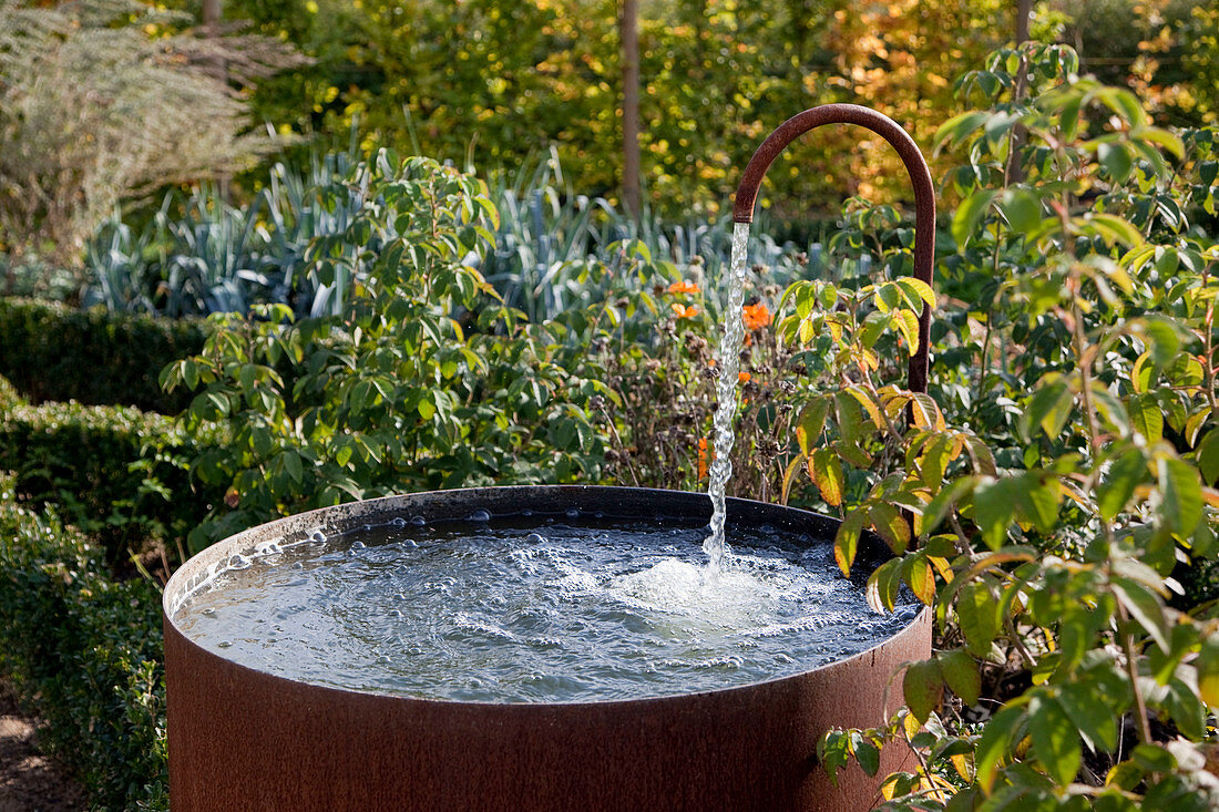 Noun: Old water barrel with copper tap in the vegetable garden