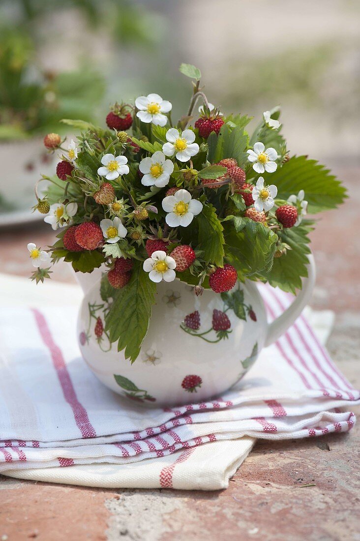 Small forest and strawberry bouquet in jug with strawberry decor