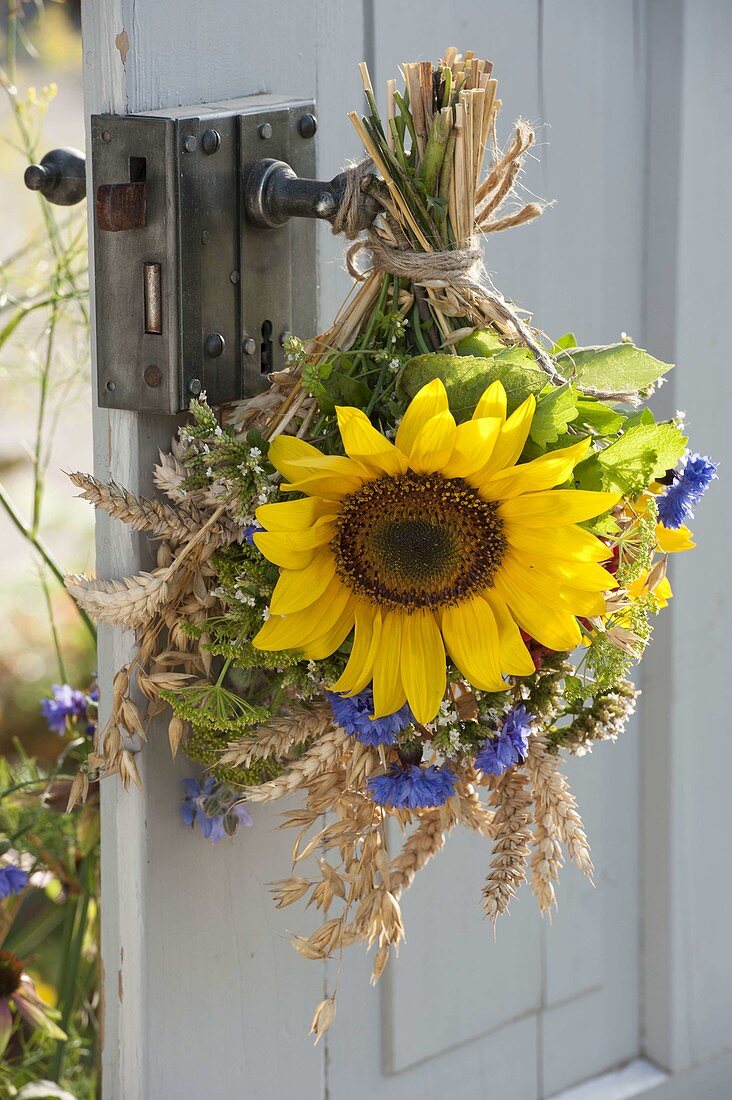 Thanksgiving bouquet on the door handle with helianthus, wheat
