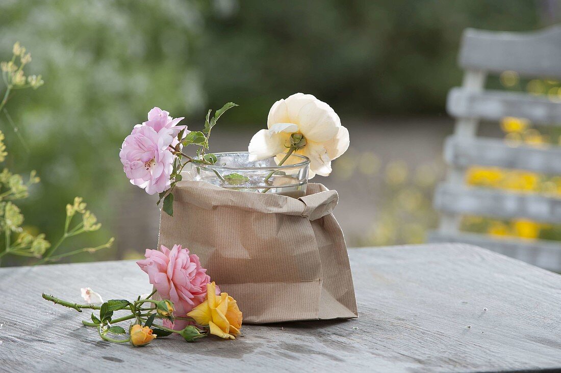 Bouquet of mixed Rosa (roses) arranged in paper bag