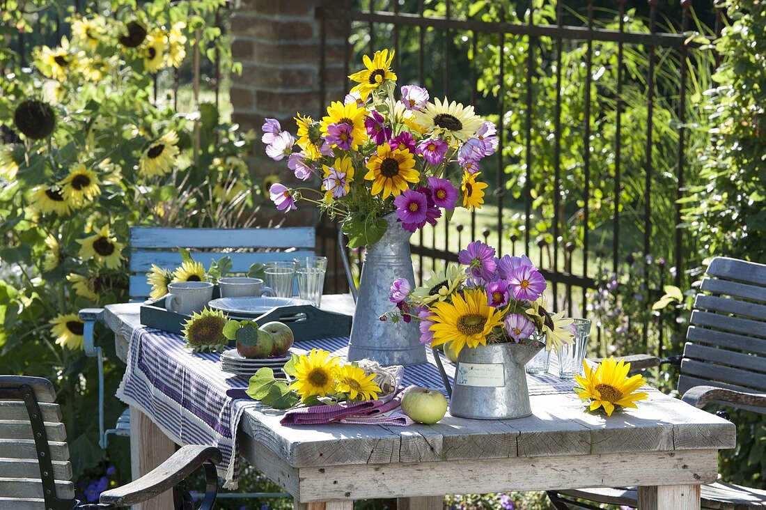 Tischdeko mit Sonnenblumen, Schmuckkörbchen und Äpfeln