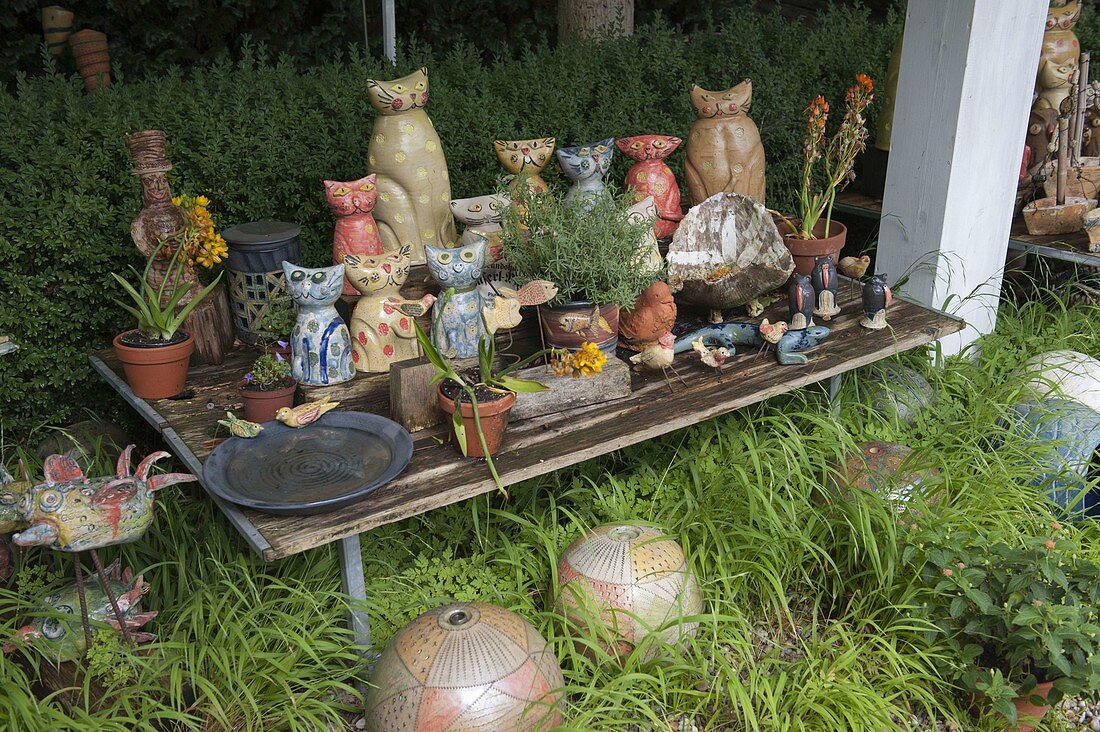 Pottery cats, balls and other decorative elements in garden
