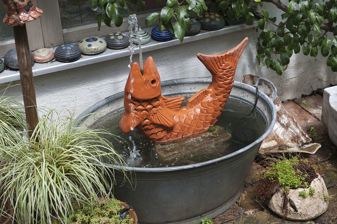 Terracotta-Fisch als Wasserspiel in Zinkwanne