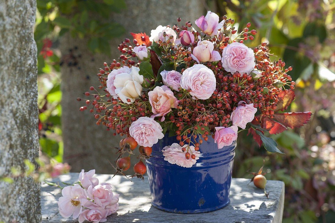 Autumn bouquet of pink (rose) and rosehips with leaves