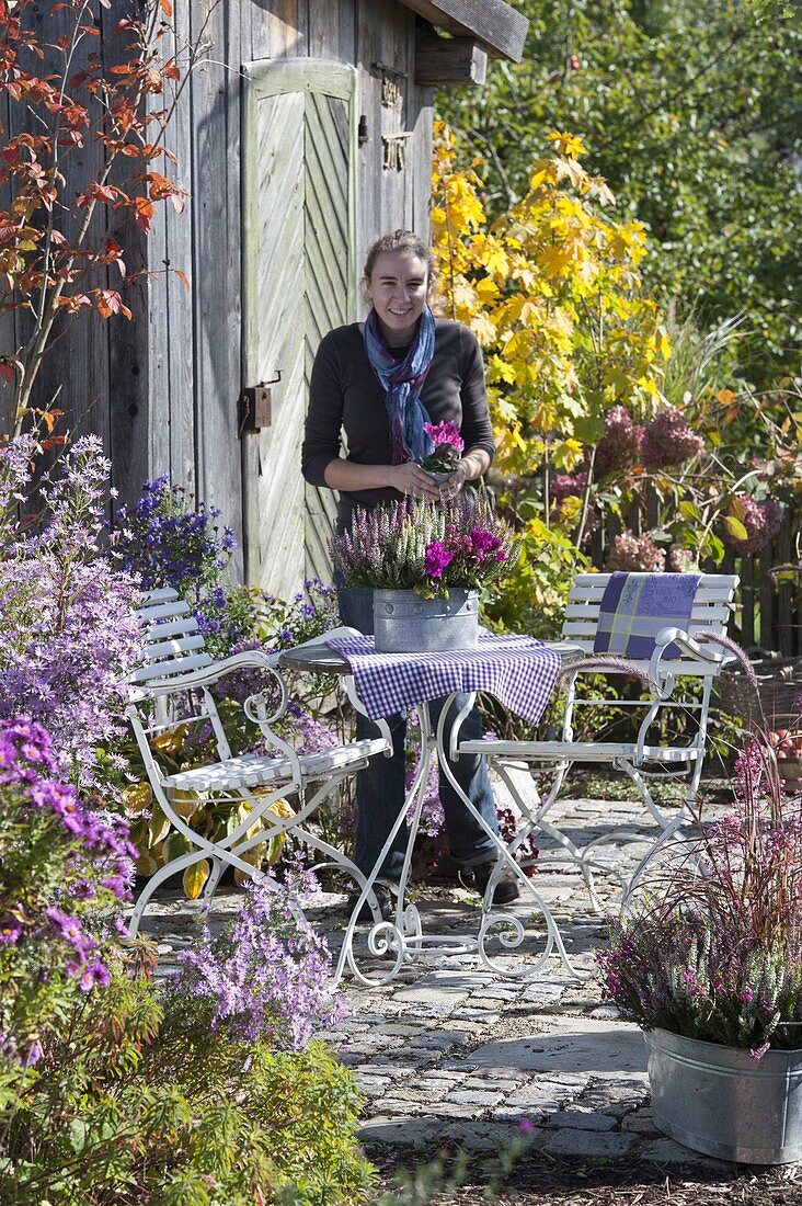 Small autumn terrace next to perennial bed at the tool shed