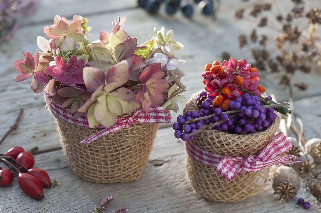 Autumn flowers and fruits in small pots wrapped with burlap