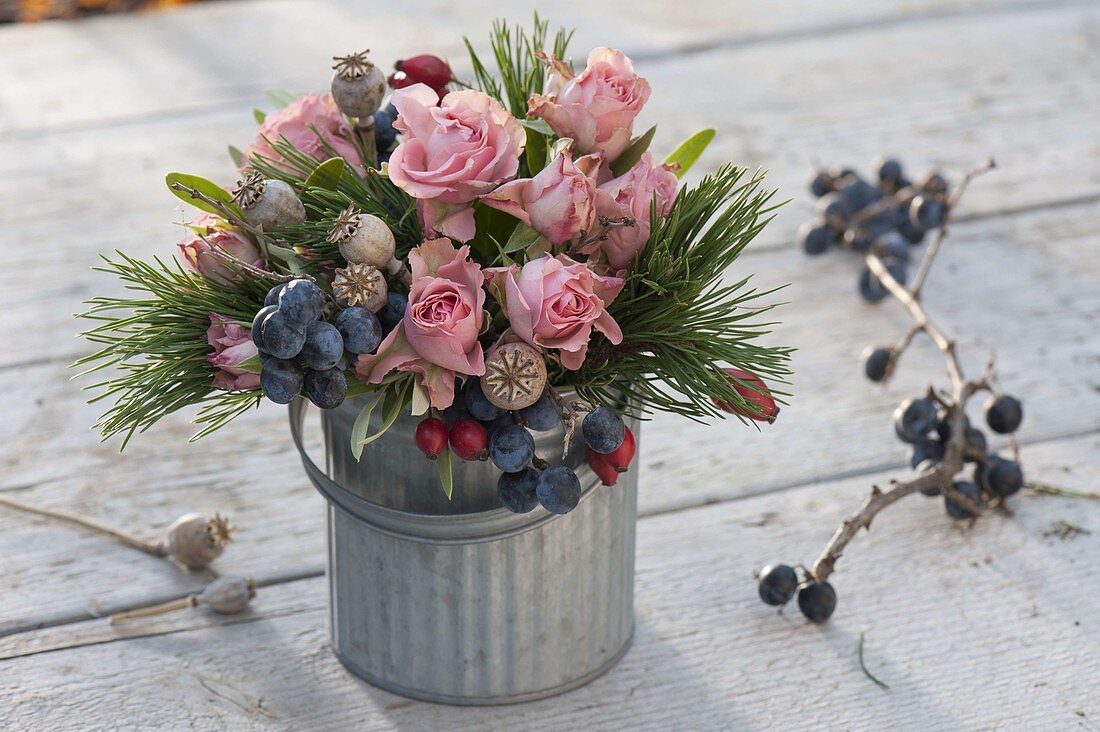 Autumn bouquet with pink (roses, rosehips), sloes (Prunus spinosa)