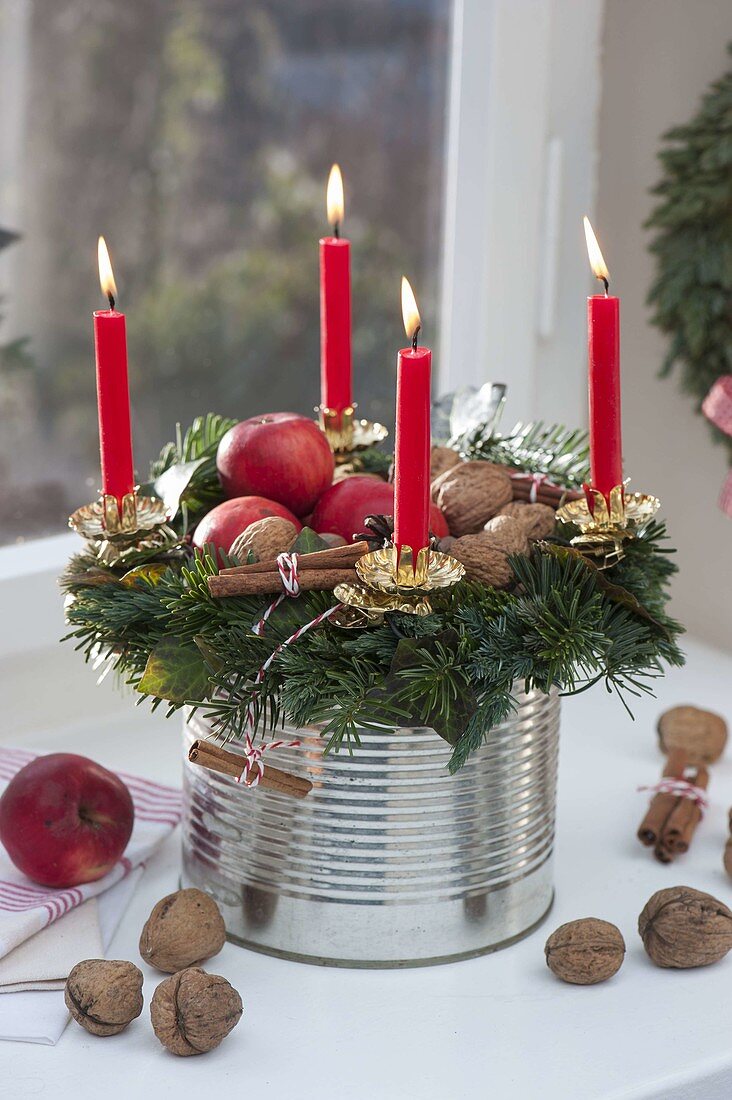 Ungewoehnlicher Adventskranz auf großer Blechdose am Fenster