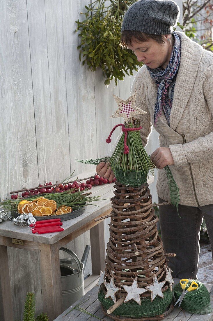 Kegel aus Weinranken als Weihnachtsbaum schmücken