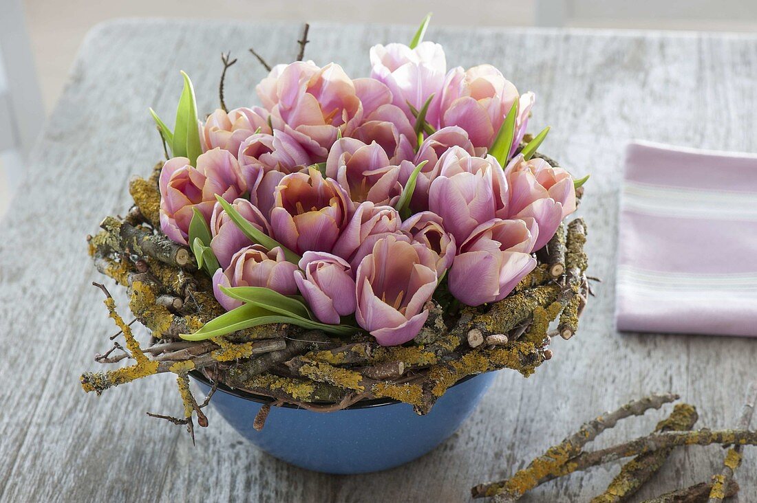 Arrangement of Tulipa (tulips) in a wreath of lichen-covered branches