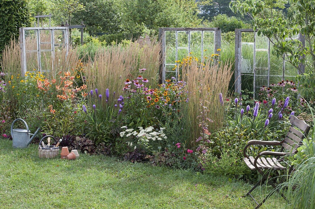 Perennial border with old windows as decorative objects