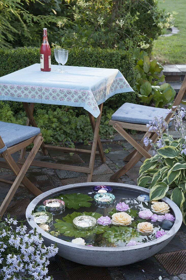 Bowl of floating rose petals and candles