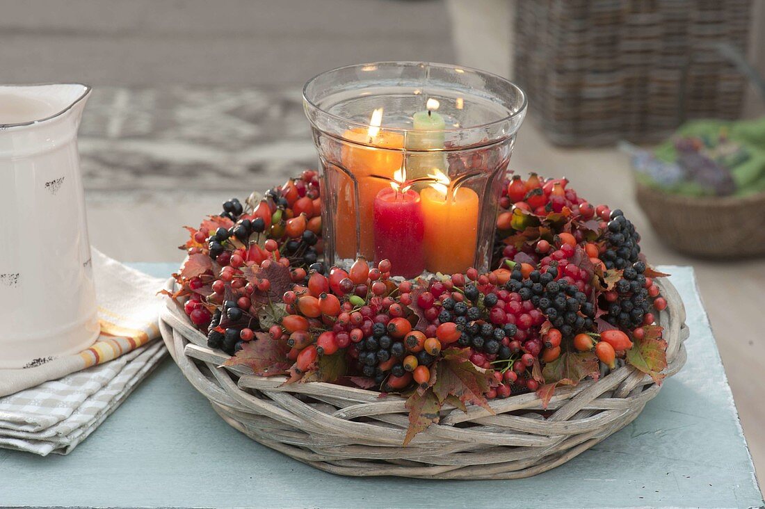 Wreath of berries and autumn leaves on a wicker bowl