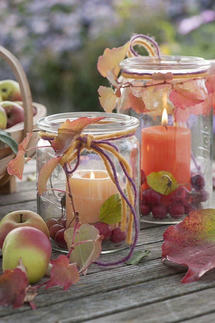 Grosse Einmachgläser als Windlichter mit Malus (Zieraepfeln, Äpfeln)