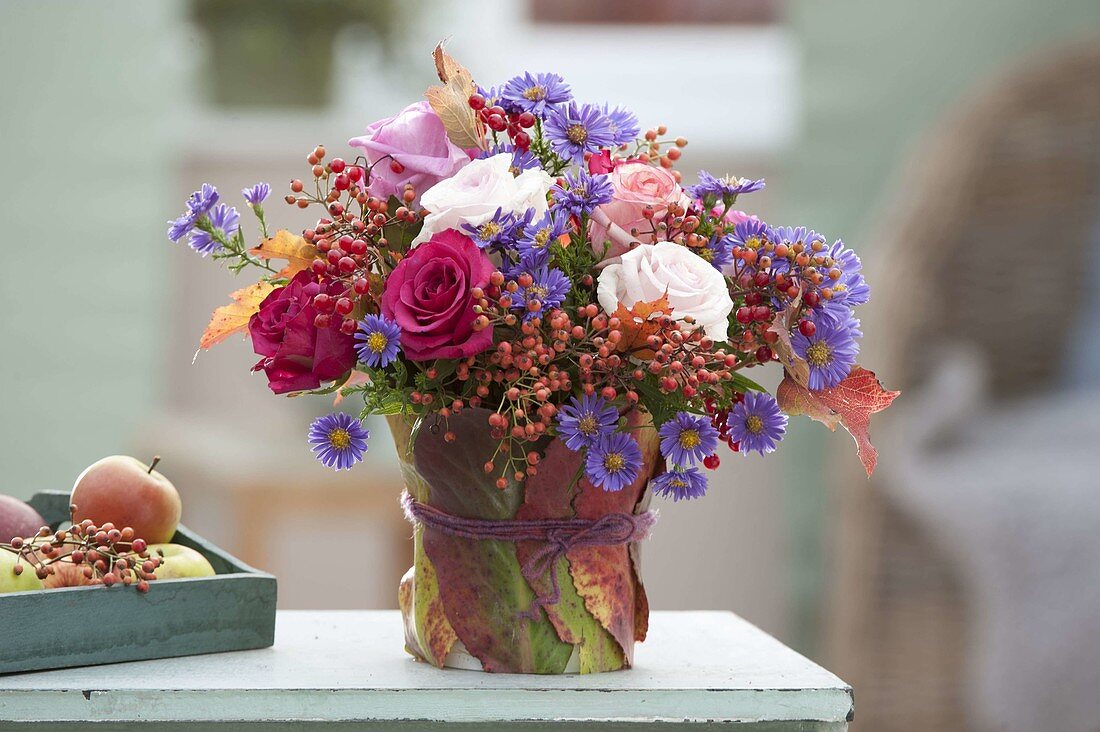 Autumn bouquet of pink (roses, rose hips) and aster (autumn asters)