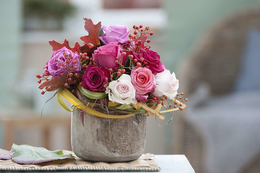 Autumn bouquet of pink (roses, rose hips) and leaves of Quercus rubra