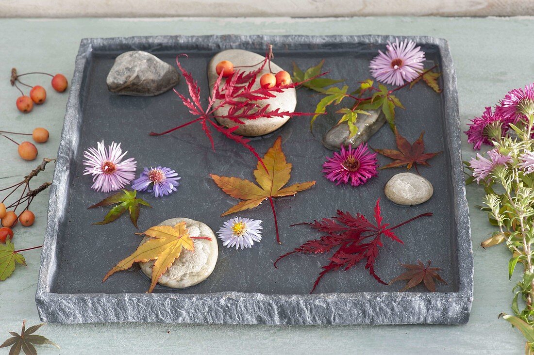 Shallow bowl with pebbles, flowers and leaves