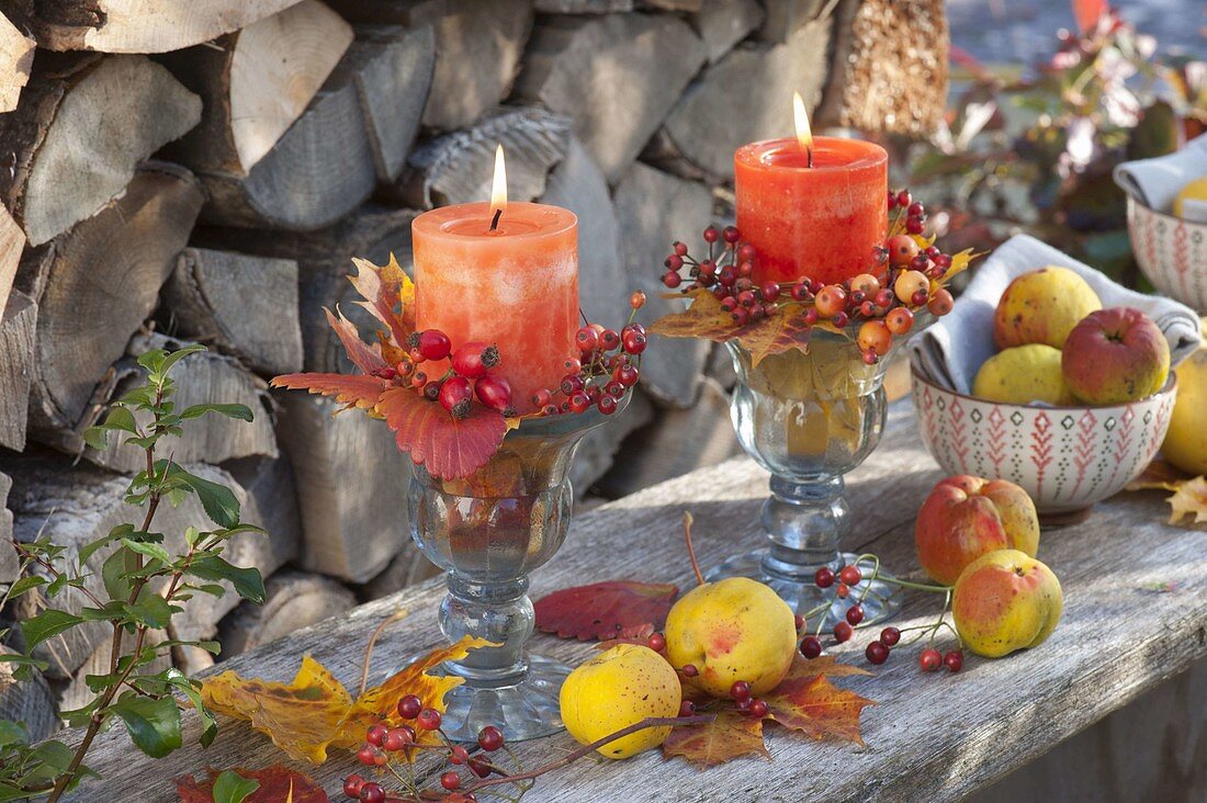 Autumnal candle decoration with leaves, pink (rosehips) and chaenomeles