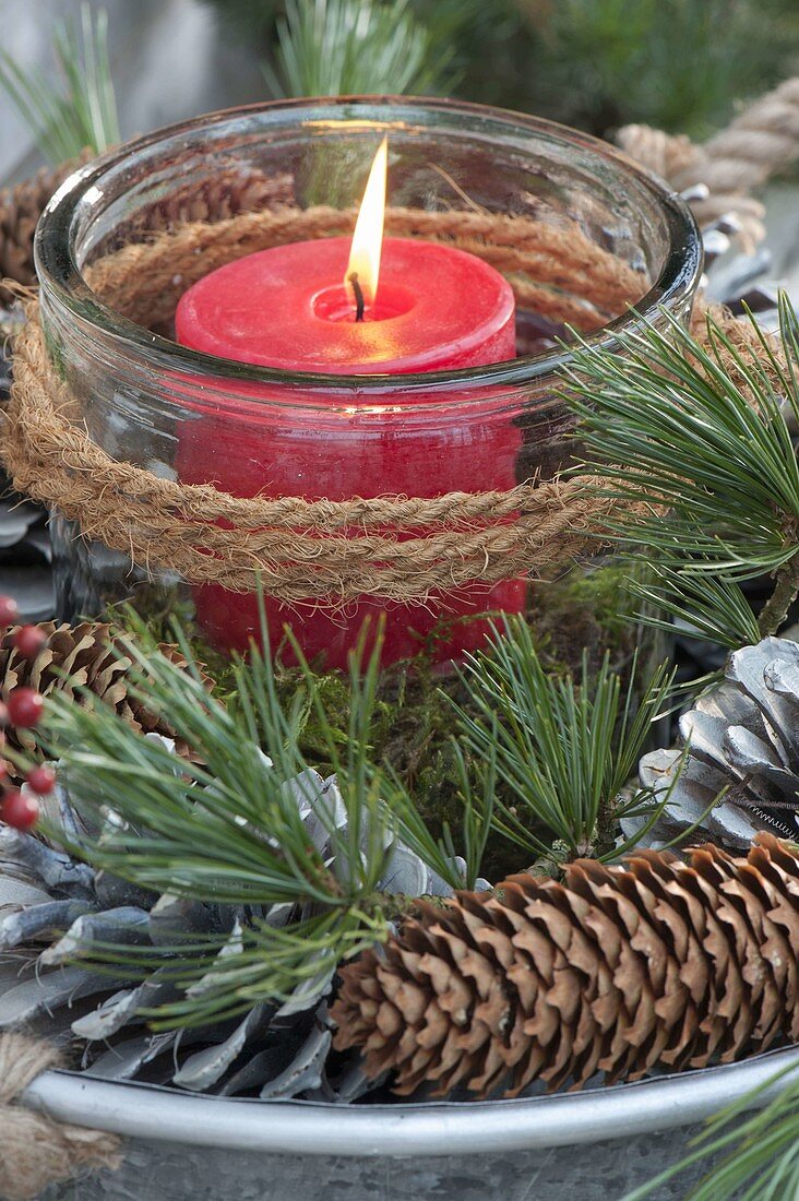 Lantern with red candle in a natural wreath made of Pinus (pine) twigs