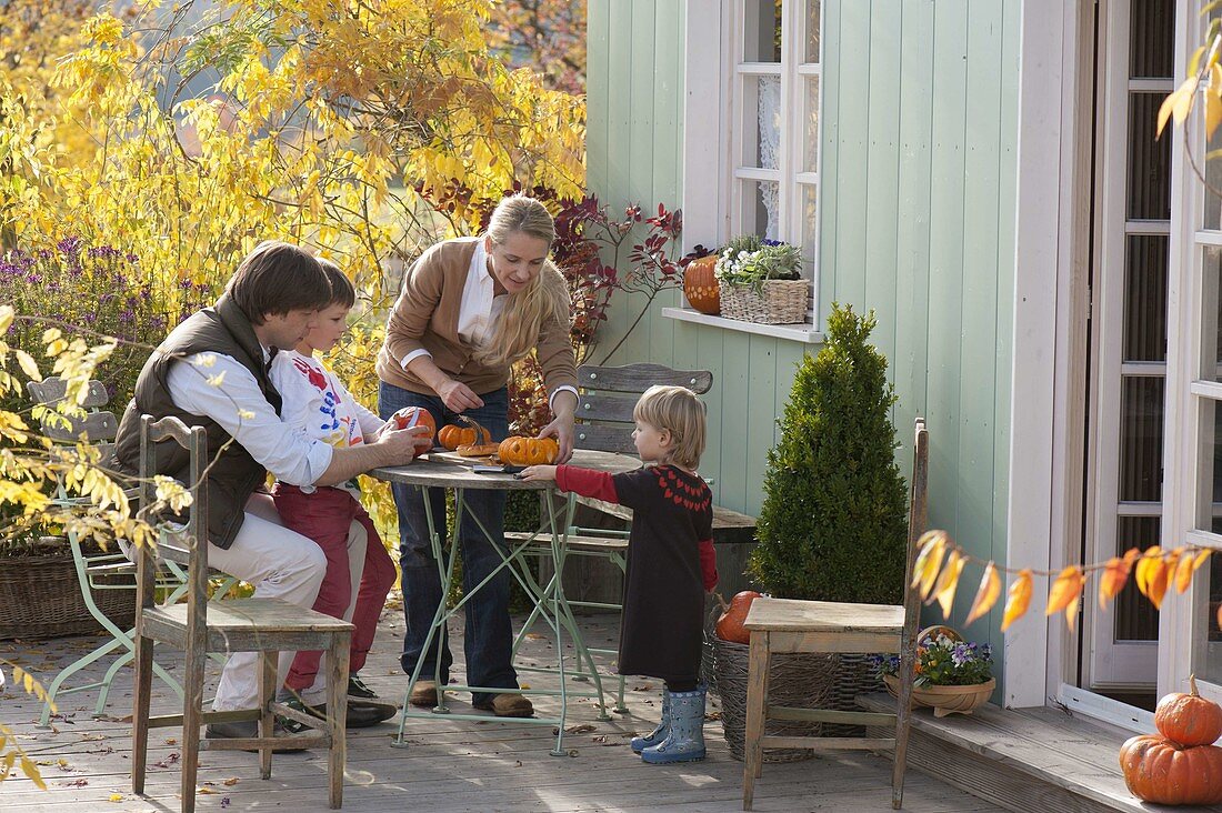 Family doing handicrafts with pumpkins