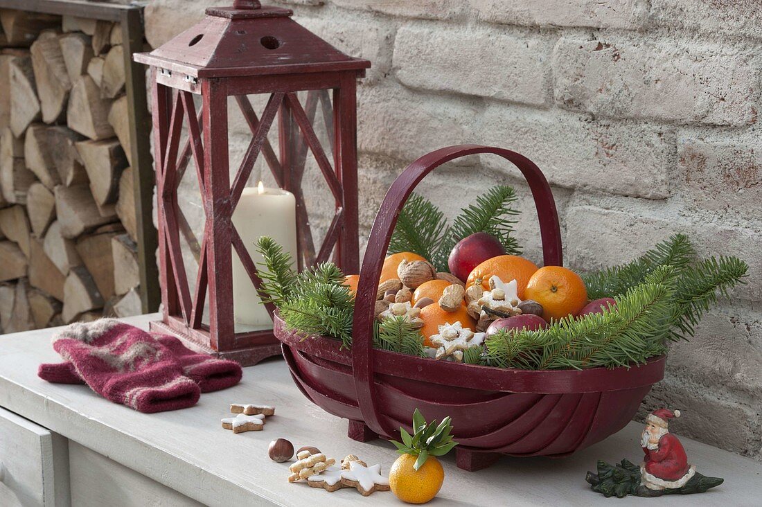 Red Santa Claus basket filled with oranges, mandarins, apples