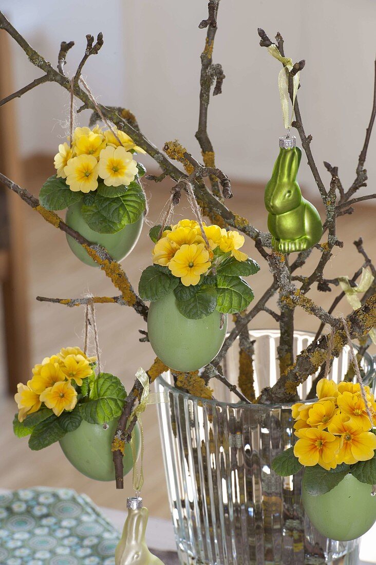 Easter bouquet of twigs, green colored duck eggs planted with primula