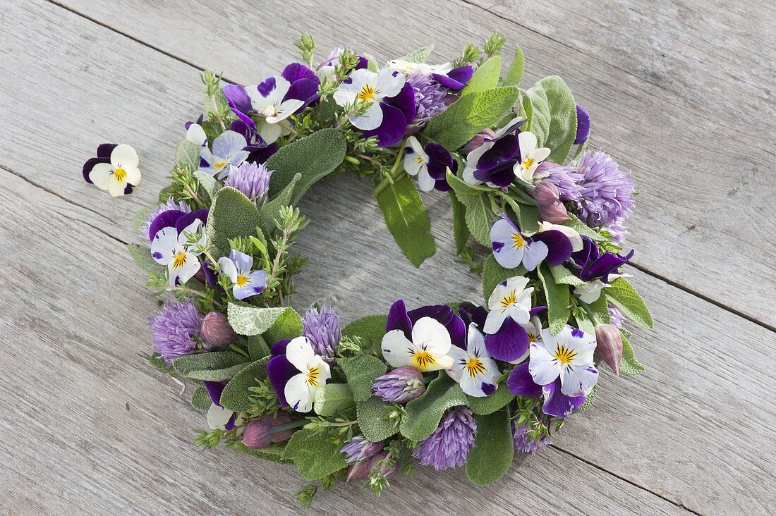 Tying a small wreath of herbs and edible flowers