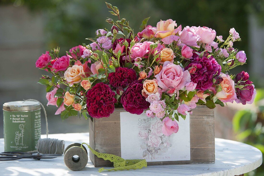 Mixed pink (rose) arrangement in wooden box with rose motive