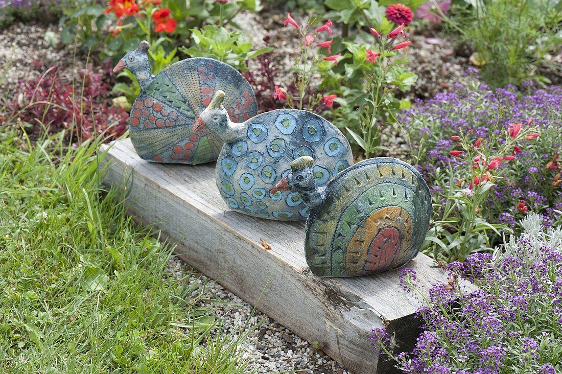 Ceramic peacocks on wooden beams at the foot