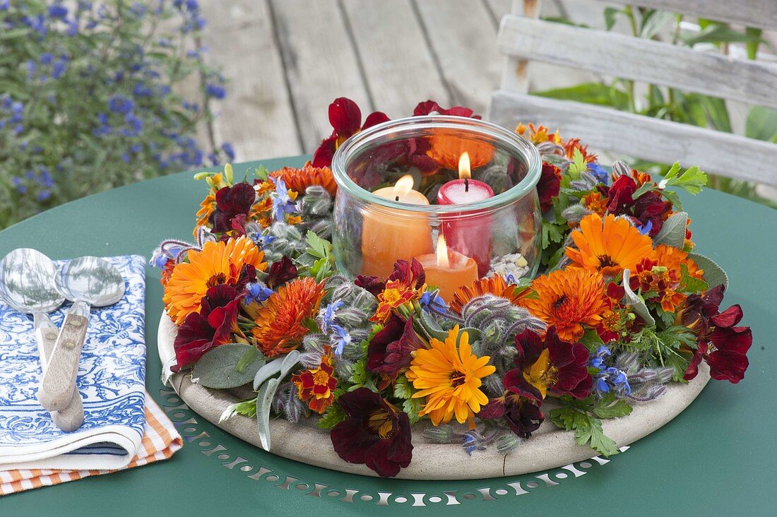 Kranz aus essbaren Blüten und Kräutern mit Einmachglas als Windlicht