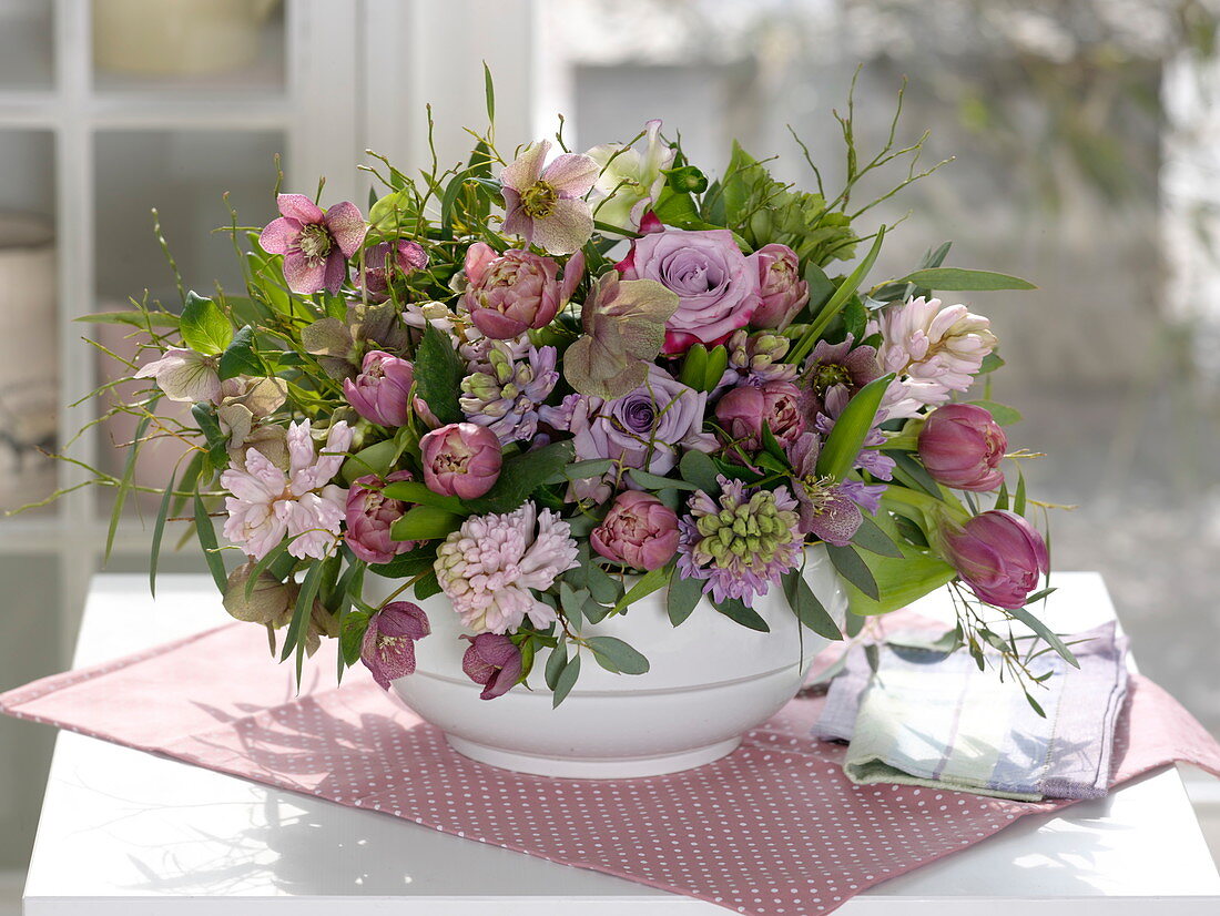 Violet-pink spring arrangement with insertion aid in soup tureen