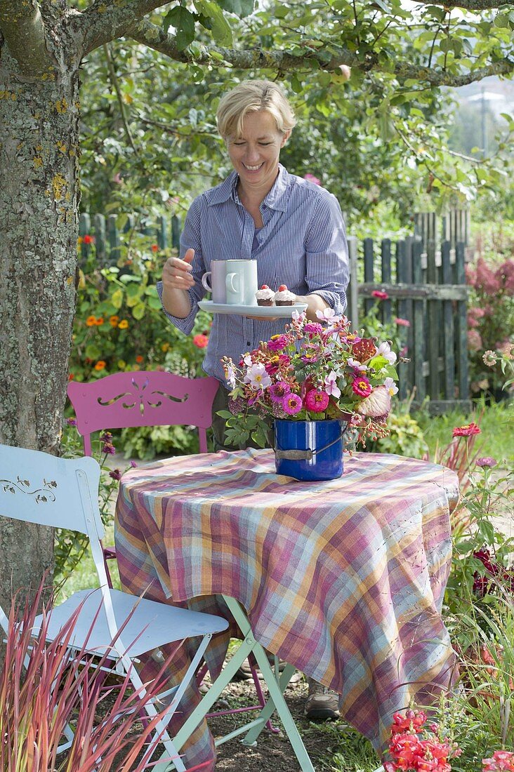 Woman covering table under apple tree