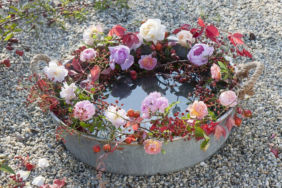 Wreath made of roses around zinc tray with water