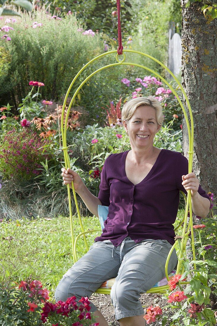 Hängender Sessel am Baum, Beete mit Sommerblumen und Stauden