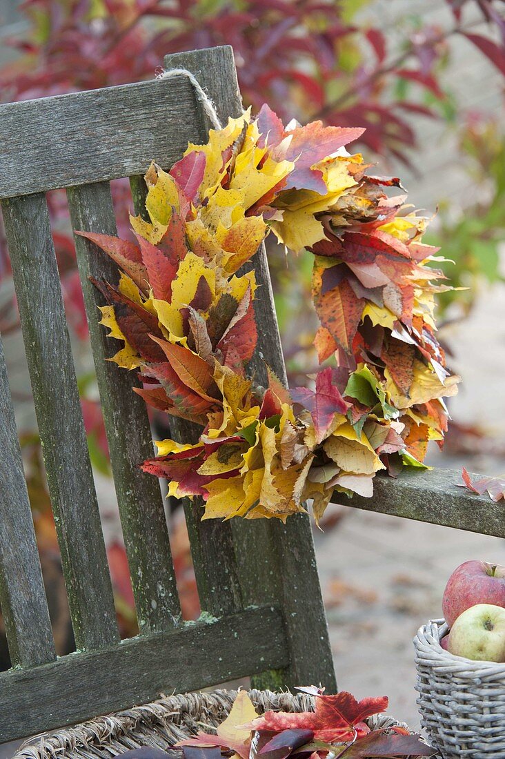 Yellow and red autumn leaves wreath hanged on bench