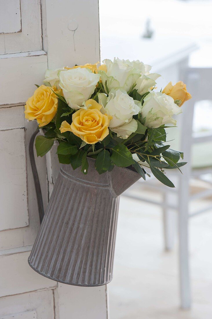 Pink (rose) bouquet in copper pot hung on door handle