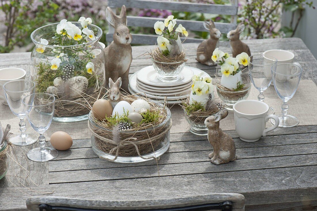 Easter table decoration with horned violets on the terrace