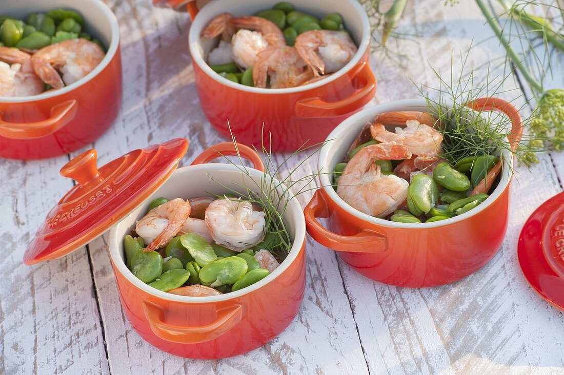 Broad beans with prawns and fennel in red oven moulds